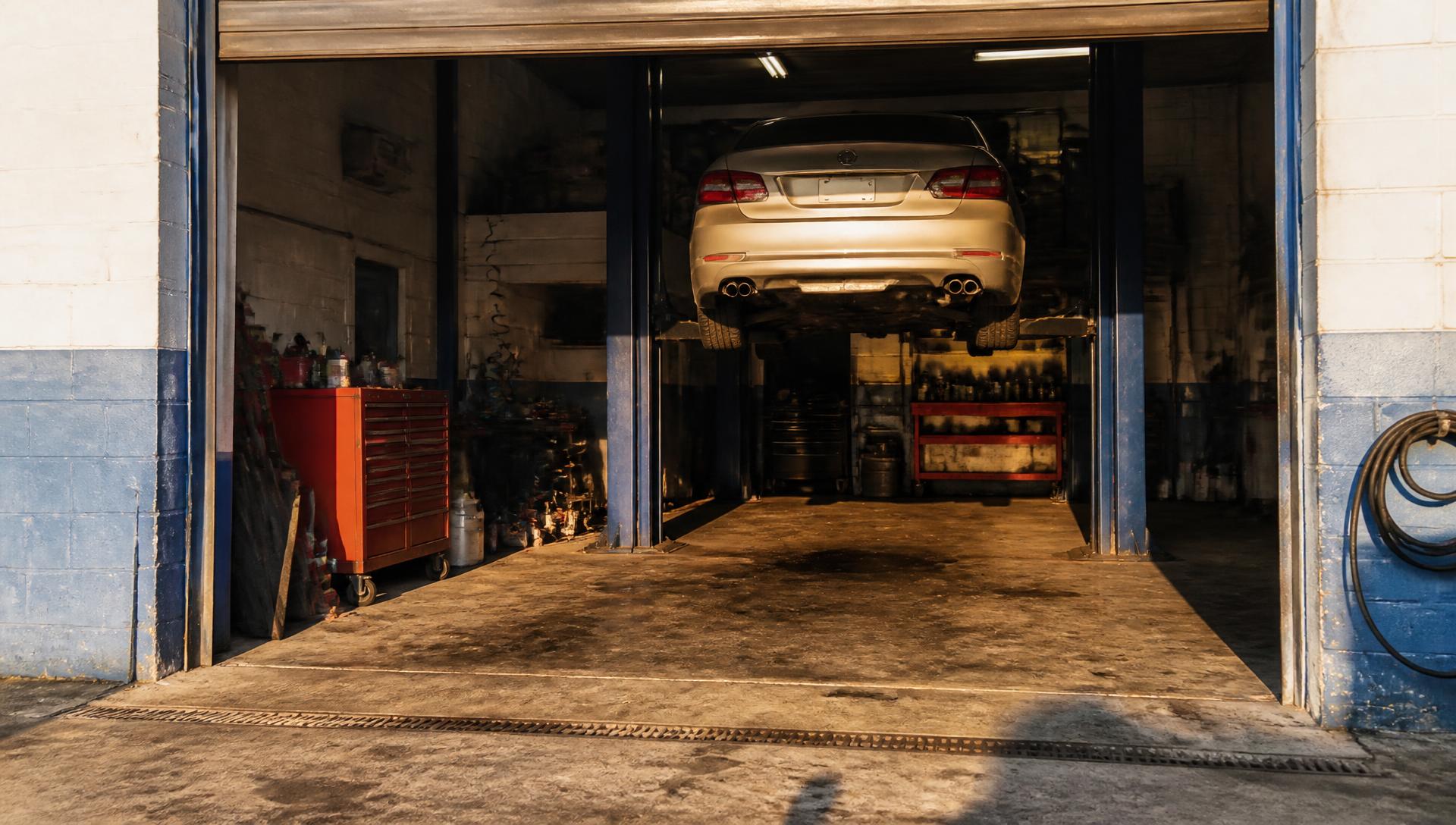 A car raised on the lift inside the open service bay at Sergio's Auto Electric